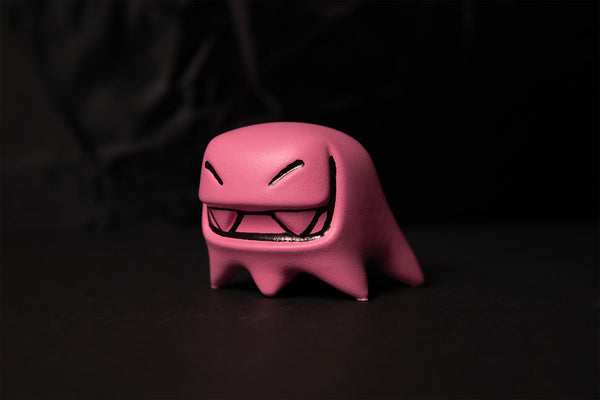 pink Mr. Fangs figurine with black eyes and mouth